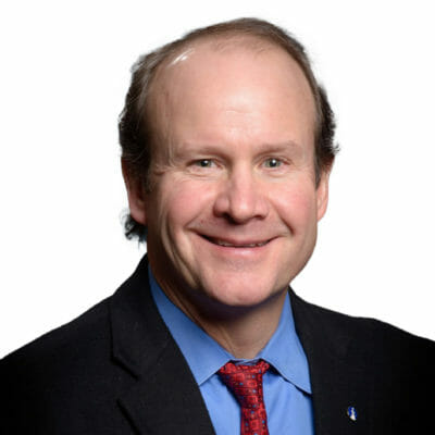 Robert Chapman from Bank of the James wearing a black suit jacket, blue button down shirt and red tie with bank of the james lapel pin